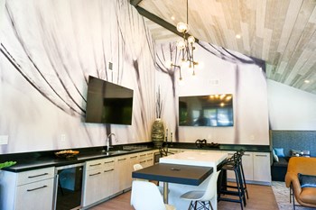 Sorelle apartments resident lounge with flatscreen TV hanging on wall and kitchen island for seating